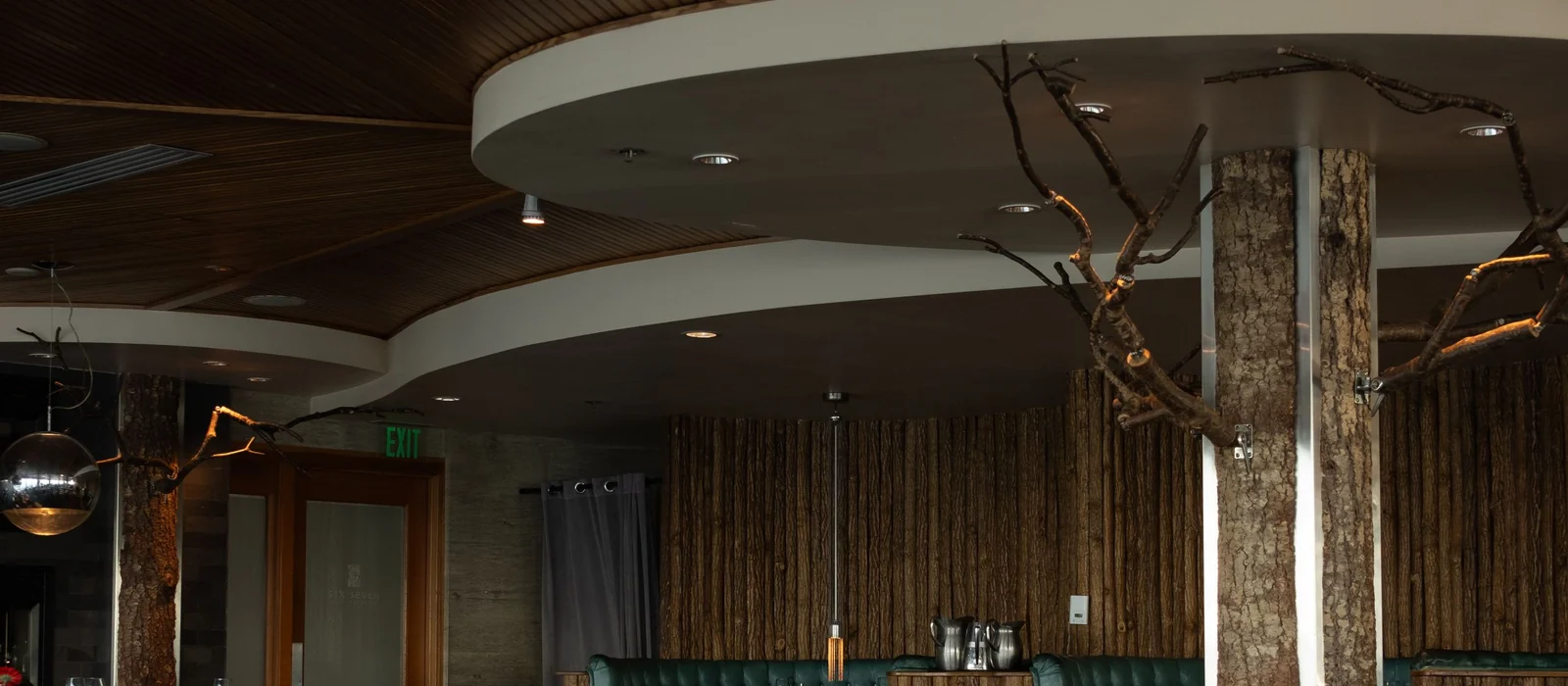 Plafond courbe équipé de luminaires apparents dans une salle de restaurant