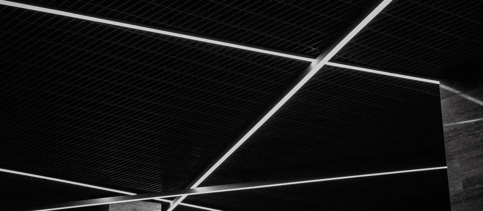 Détail graphique de profilés lumineux linéaires sur un plafond sombre