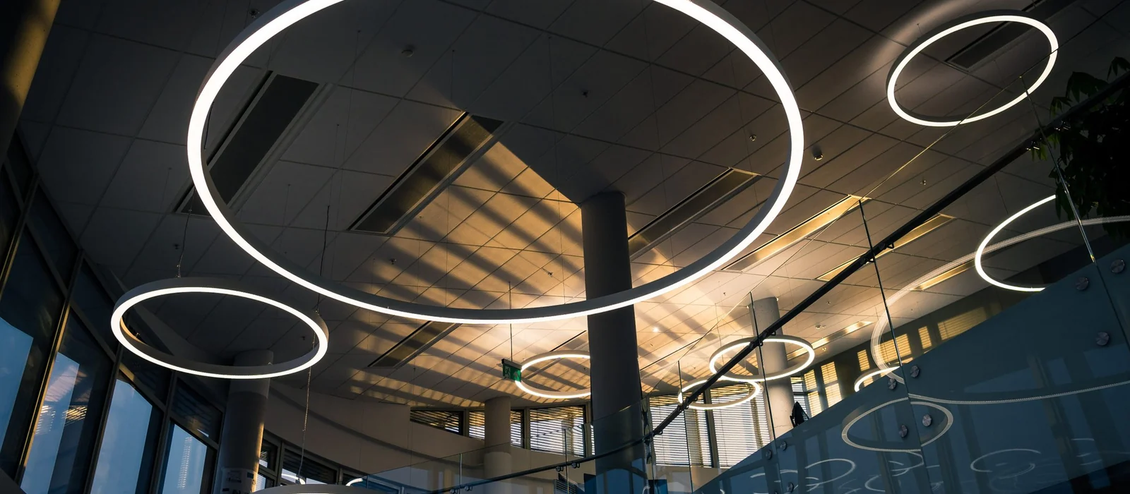 Anneaux lumineux suspendus dans un espace de travail contemporain