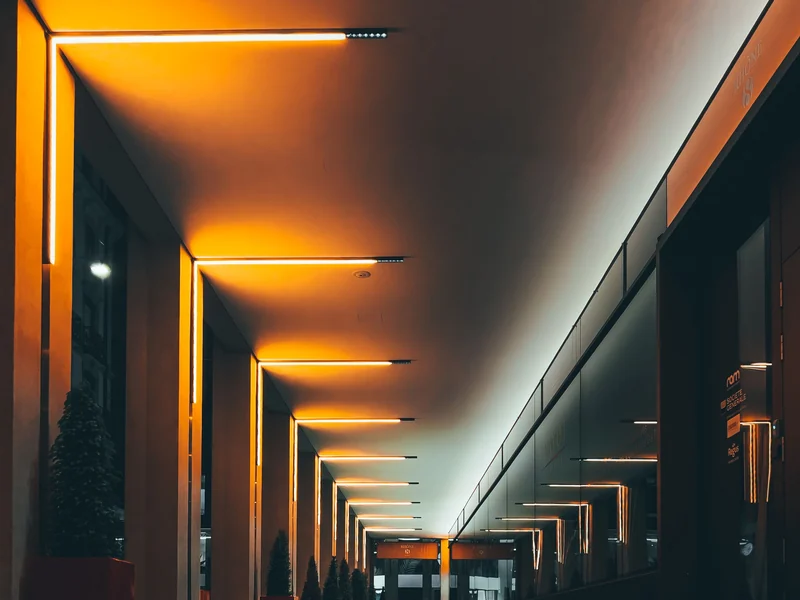 Lignes lumineuses continues intégrées dans un plafond en bois